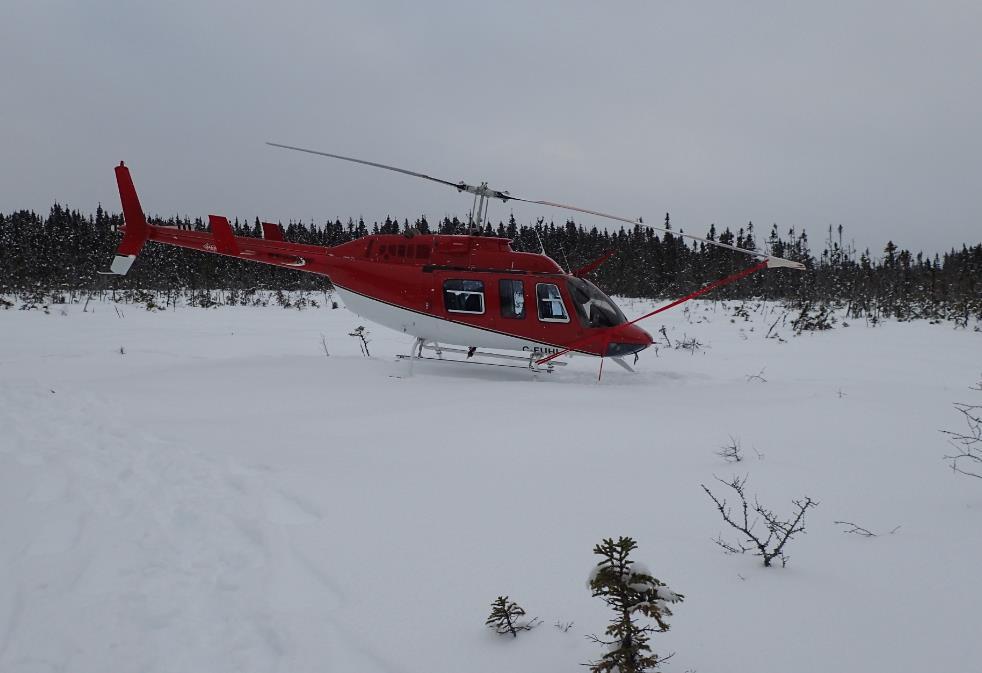 Red helicopter on snow during historical fieldwork at Caledonia Brook